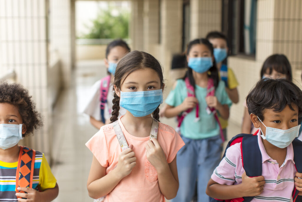 Kids walk to school with masks on 