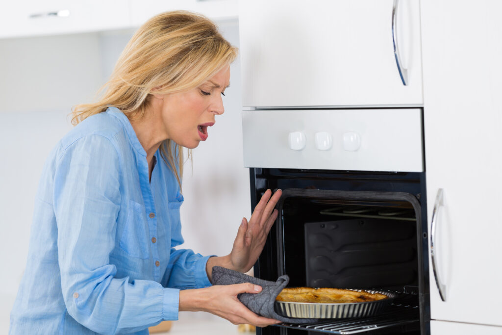 woman burns hand on oven